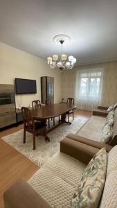 sala de estar con mesa de comedor y TV en Salamat Apartments - Best location 8, en Bishkek