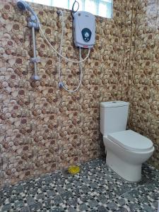 uma casa de banho com um WC numa parede de pedra em Perhentian Chomel Chalet em Ilhas Perhentian