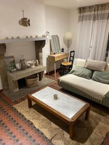 a living room with a couch and a table at La petite maison de Coline in Réville