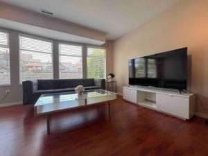 un soggiorno con una grande TV a schermo piatto di Spacious 2 bedroom suite a Port Coquitlam