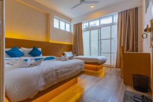 a hotel room with two beds and a window at POKHARA APARTMENTS INN in Pokhara