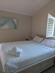 Un dormitorio con una cama con una toalla. en Byron Bay Beachfront Apartments en Byron Bay