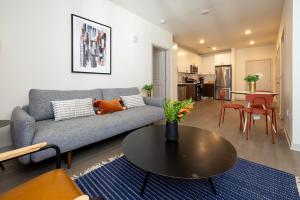 a living room with a couch and a table at TWO Modern Nulu CozySuites in Louisville