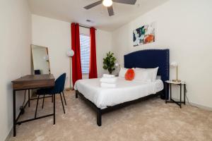 a bedroom with a bed and a desk and a mirror at TWO Modern Nulu CozySuites in Louisville