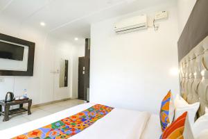 a hotel room with a bed and a tv at FabHotel Madhuban Inn in Rishīkesh