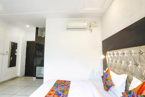 - une chambre avec un lit et une tête de lit dans l'établissement FabHotel Madhuban Inn, à Rishikesh