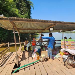a group of people standing under a roof on a dock at Banlung Mountain View Treks & Tours in Banlung