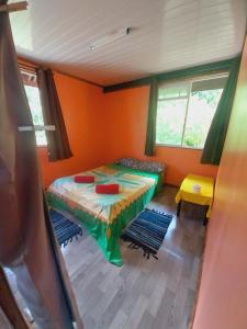 1 dormitorio con 1 cama en una habitación con paredes de color naranja en Papehau Room en Fare