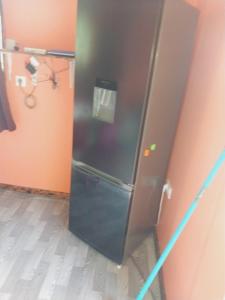 um frigorífico preto num quarto com em Papehau Room em Fare