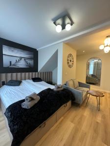 a bedroom with a bed and a couch and a clock at Apartamenty Beauty & SPA in Ełk