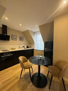 a kitchen with a table and two chairs in a room at Apartamenty Beauty & SPA in Ełk +102 photos