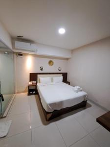 a bedroom with a large white bed in a room at Hotel Morena Batam in Batam Center