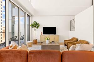 uma sala de estar com um sofá e uma televisão em @ Marbella Lane - Luxe 3BR Penthouse in Long Beach em Long Beach