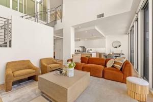 uma sala de estar com um sofá e duas cadeiras e uma mesa em @ Marbella Lane - Luxe 3BR Penthouse in Long Beach em Long Beach