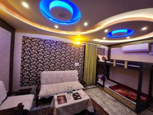 Cette chambre dispose d'un canapé et d'un lit avec des lumières bleues. dans l'établissement Dk's Paradise Homestay, à Agra