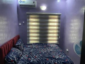 a bedroom with a bed and a large window at Belphus Apartments in Lagos
