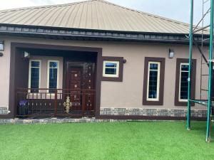 a house with a green lawn in front of it at Belphus Apartments in Lagos