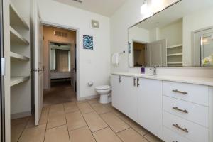 La salle de bains est pourvue de toilettes, d'un lavabo et d'un miroir. dans l'établissement TWO Modern Nulu CozySuites, à Louisville