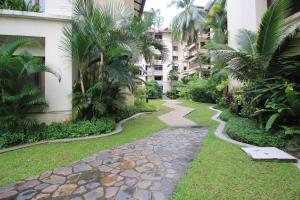 a walkway in the middle of a courtyard with palm trees at A Tranquil Retreat Near PWTC & KLCC in Kuala Lumpur