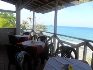 a restaurant with tables and chairs with a view of the ocean at Hotel Sol y Luna in Capurganá