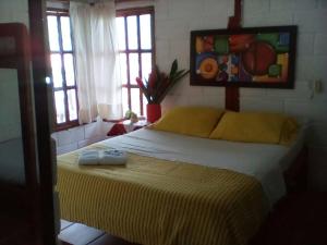a bedroom with a bed with a painting on the wall at Hotel Sol y Luna in Capurganá