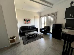 sala de estar con sofá negro y silla en Modern Studio - Amitié/Point E, en Dakar
