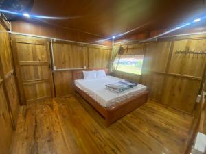 małą sypialnię z łóżkiem w drewnianym pokoju w obiekcie Công homestay w mieście Làng Xa