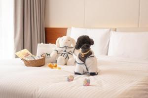 two stuffed animals sitting on top of a bed at Somerset Jeju Shinhwa World in Seogwipo