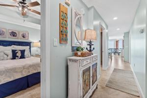 a bedroom with a blue bed and a hallway at Gulfside 402 - True Luxury BEACHFRONT at Destin West - Best View in the Resort! in Fort Walton Beach
