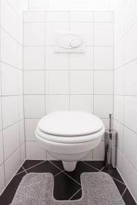 a white toilet in a white tiled bathroom at #29 Heaven Messe/Prater in Vienna