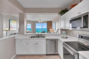 a kitchen with white cabinets and a view of the ocean at Destin West Gulfside 301 - True Beachfront Luxury - Beautiful Views! in Fort Walton Beach