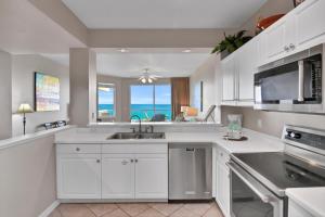 een keuken met witte kasten en uitzicht op de oceaan bij Destin West Gulfside 301 - True Beachfront Luxury - Beautiful Views! in Fort Walton Beach