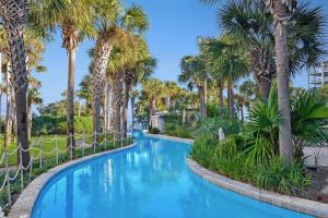 een zwembad met palmbomen in een resort bij Destin West Gulfside 301 - True Beachfront Luxury - Beautiful Views! in Fort Walton Beach