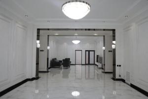 a hallway of a building with a chandelier at Status Hotel in Qarshi