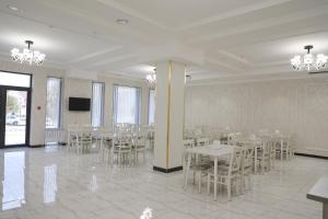jadalnia ze stołami i krzesłami oraz telewizorem w obiekcie Status Hotel w Karszy