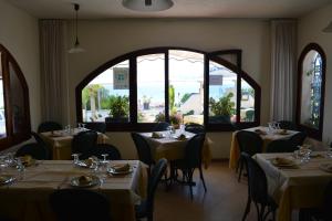 um restaurante com mesas e cadeiras e uma grande janela em Hotel Miramare Garzia em Marinella di Selinunte