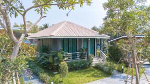 Casa pequeña con porche y árboles en SeeView Resort (ซีวิว รีสอร์ต) en Ban Pak Nam