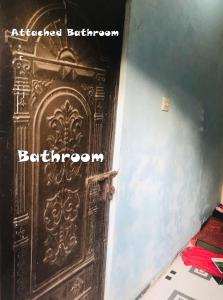 an old wooden door in a room with the words bathroom at Grand Mess in Comilla