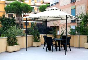 - une table et des chaises sous un parasol sur la terrasse dans l'établissement Royal House Vaticano, à Rome