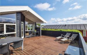 a deck with chairs and a table on a house at Søhus in Fæbæk
