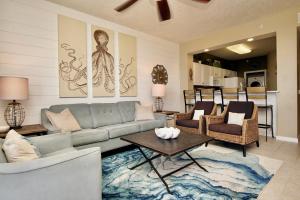 uma sala de estar com um sofá e uma mesa em Destin West Gulfside 404 - Amazing Beach View - Free Beach Service - Must See! em Fort Walton Beach