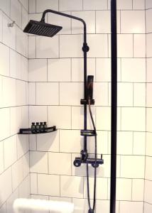 um chuveiro na casa de banho com azulejos brancos em Glue Hotel em Seul
