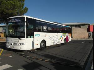 a white bus is parked in a parking lot at Hotel De La Bastide in Carcassonne