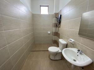 a bathroom with a toilet and a sink and a phone at KSP Guest House in Melaka