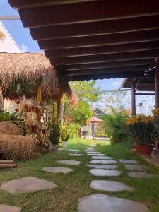 a walkway in a yard with a straw roof at Mộc House in Kon Tum Kơ Pang