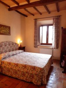 Un dormitorio con una cama grande y una ventana en agriturismo il Borgo en Cetona