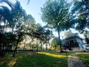 una casa in un parco con alberi e erba di Sleep Home Khaoyai a Pak Chong