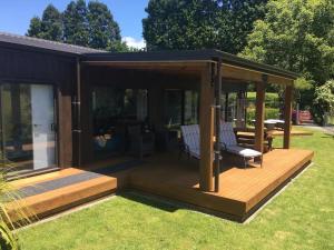 a gazebo with two chairs on a wooden deck at Kaimai Range Country Getaway in Katikati