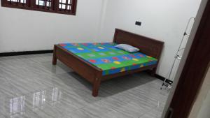 a small bed sitting in a room with at Family Villa Thalpavila in Ambatenna