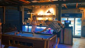 a man and a woman playing pool in a bar at Revolution Chiang Mai - Old Town in Chiang Mai